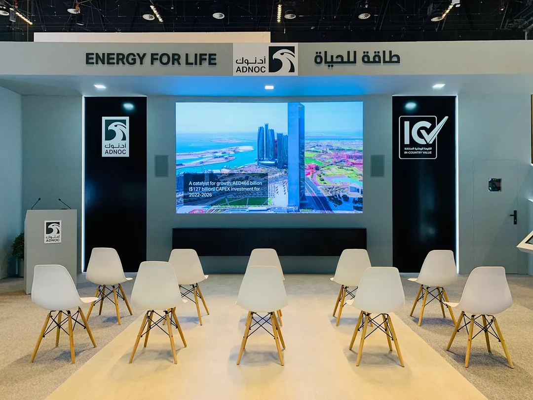 Large LED presentation wall supporting live demonstrations at the ADNOC exhibition stand