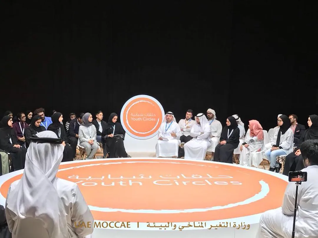 Abu Dhabi Sustainability Week Youth Circles forum with participants seated around a large branded circular discussion stage