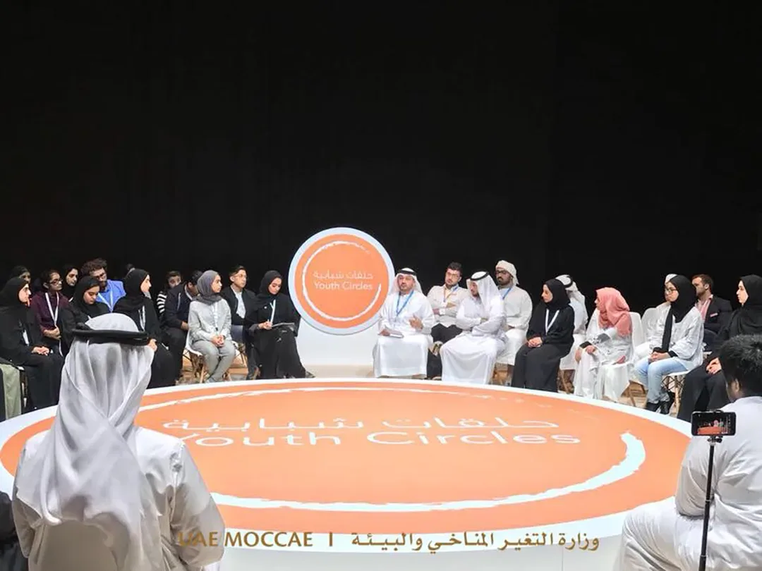 Abu Dhabi Sustainability Week Youth Circles forum with participants seated around a large branded circular discussion stage