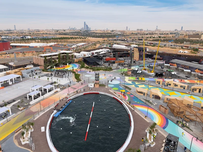 Aerial view of colorful spiral ground graphics, geodesic domes, and festival site infrastructure engineered by Evolution