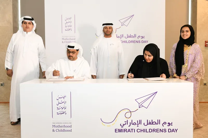Emirati Children’s Day agreement signing ceremony with representatives and young participants in front of a branded Motherhood and Childhood backdrop