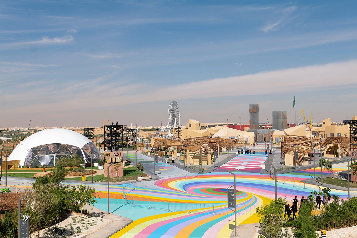 Aerial view of colorful spiral ground graphics, geodesic domes, and festival site infrastructure engineered by Evolution