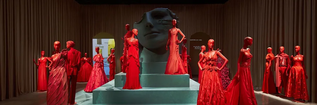Rome-inspired scenic architecture, a Colosseum centrepiece and crafted sculptural displays translated Valentino’s heritage into a physical exhibition at M7 Doha.